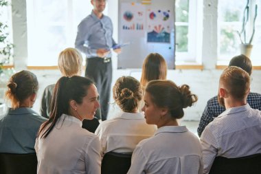 Erkek lider iş toplantısında konuşma yapıyor. Konferans salonunda dinleyiciler. Konferans, eğitim, planlama, öğrenme, koçluk, iş. Panoramik kompozisyon pankartlar için uygun.