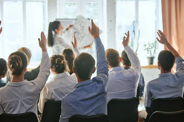 Conference, group of business people with hands for vote, questions or answers. Corporate event, meeting and hand raised in training seminar. Training, planning, learning, coaching, business concept