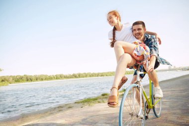 Çiftler için mutluluk ve neşe, açık havada güneşli deniz kenarında aynı motosiklette seyahat ederek başlar ve eğlenir. Parlak randevu. Romantik, tatil, aktif yaşam tarzı kavramı, takılmak..