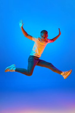 Zafer kazanan adamın neon ışıklı portresi yıldız formunda zıplayan, sevinç çığlıkları atan, galibiyeti kutlayan, heyecanlı duygular. Güzellik, moda, gençlik, satış, hayranlar.