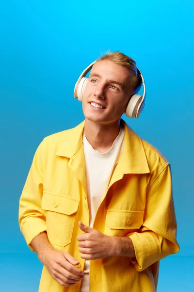 若いハンサムな男の肖像画 明るいファッションの衣装やヘッドフォンの学生は ブルーの背景で孤立している 人間の感情 研究の概念 — ストック写真