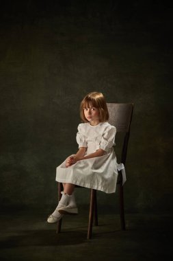 Çekici küçük bir kızın portresi, beyaz elbiseli bir çocuğun klasik arka planı. Peri prensesi mi kraliçe mi? Masalların kahramanı. Fantezi, çocukluk, hayaller, peri masalı, kitap. Ad.