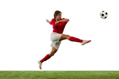 Rekabetçi genç bir kadın, hareketli bir futbolcu, beyaz arka planda izole bir şekilde topa vuruyor. Profesyonel spor kavramı, rekabet, oyun, eğitim, gençlik, aksiyon, reklam
