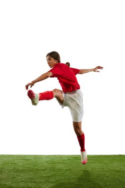 Genç sporcu kızın dinamik görüntüsü, hareket halindeki futbol katmanı, beyaz arka planda izole edilmiş topu tekmeliyor. Profesyonel spor kavramı, rekabet, oyun, eğitim, gençlik, aksiyon, reklam