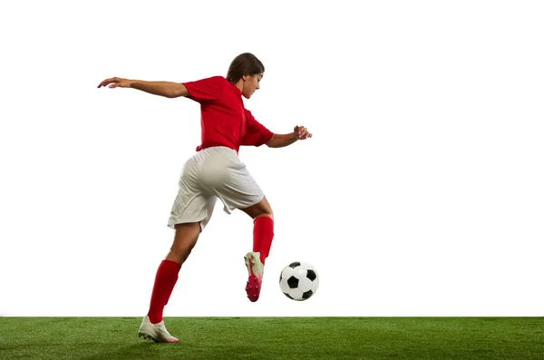 Winning game. Young athletic girl, football player in motion during game, playing isolated over white background. Concept of professional sport, competition, game, training, youth, action, ad