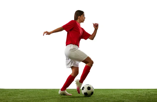 Motivated young sportsman, girl, football player in motion, dribbling ball isolated over white background. Success. Concept of professional sport, competition, game, training, youth, action, ad