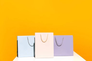 Büyük indirim. Kara Cuma. Alışveriş indirimi. Sarı arka planda izole edilmiş üç renkli kağıt torbanın fotoğrafı. Moda, güzellik, dükkan, satış elemanı, marka, trend konsepti. kopyalama alanı. ad