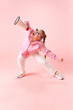 Büyük beden kadın portresi, şık giyinmiş, gözlüklü pembe arka planda Kara Cuma 'yı başlatmak için megafona bağırıyor. Moda, iş, alışveriş anlayışı. Ad