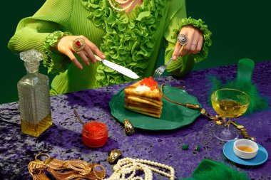 Aristokrat kahvaltısı. Yemek ve sanat fotoğrafçılığı. Tanınmayan bir kadın masasında havyarla krep yemeye başlıyor. Antika, 80 'ler, 70' ler tarzı. Tamamlayıcı renkler. Yemek, moda, tarz kavramı.