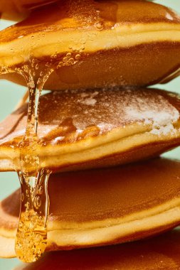 Yemek ve sanat fotoğrafçılığı. Kapatın. Tatlı, lezzetli, sıcak, tatlı krepler üzerine şerbet damlıyor. Eski moda, 80 'ler, 70' ler tarzı. Tamamlayıcı renkler. Fast food, moda, tarz ve tat kavramı. Ad