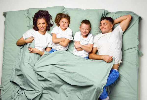 Ovanifrån Människor Täckta Med Filt Liggande Sängen Barn Korsade Händer — Stockfoto