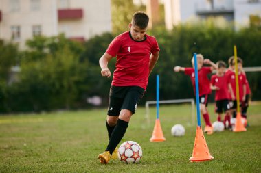 Okul futbolcusunun yakın plan portresi. Sporda top sürüyor, futbol sahası hareket halinde. Futbol oynuyordum. Çocuklar takım oyunu. Spor yaşam tarzı, aktivite, hobi anlayışı. Ad.