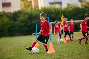 Futbol sahasında spor üniformalı bir antrenman topunun okul oyuncusunun portresini yakından çek. Futbol oynuyordum. Çocuklar takım oyunu. Spor yaşam tarzı, aktivite, hobi, egzersiz kavramı. Ad