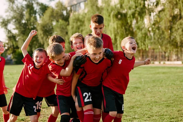 幸せな子供のサッカー選手は スコアスコアのゴール後に喜んで運動のフットボールフィールドにチームします サッカーをする スポーツの種類 スポーツライフスタイル レジャー活動のコンセプト アドベンチャー — ストック写真