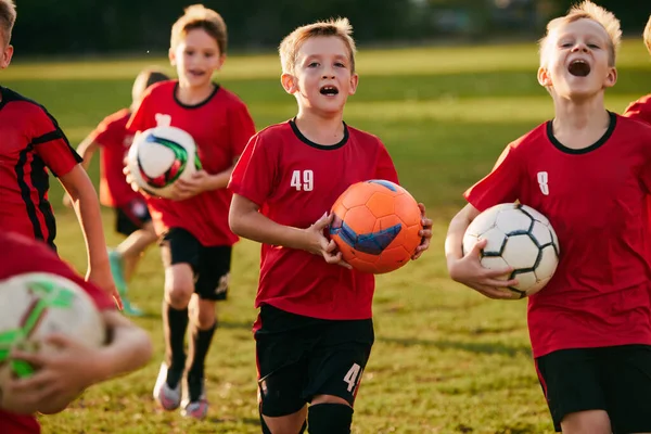 スポーツでボールを保持している子供のサッカー選手の肖像画を閉じる 運動中のサッカーフィールド サッカーをする 子供のチームゲーム スポーツライフスタイル アクティビティ 趣味の概念 アドベンチャー — ストック写真