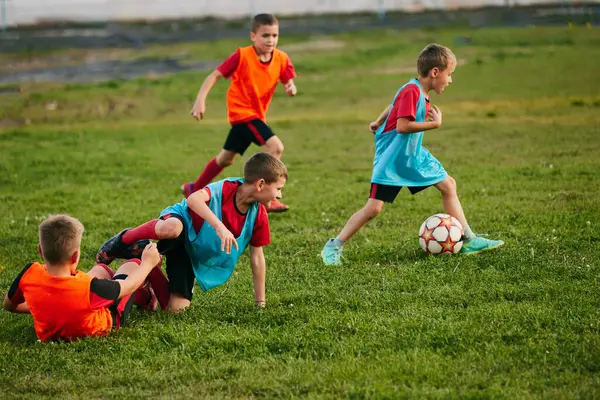 ジャージとクリーツでスポーツユニフォームを着用している競争力のある小さな選手 子供たちはサッカー場でサッカーをする 子供の学校のチーム スポーツ 健康的なライフスタイル アクティビティ 趣味の概念 — ストック写真