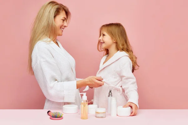 Portrait of beautiful mother having fun with daughter in bathroom. Woman and child together care of beauty, health. Cosmetics and wellness of skin. Concept of beauty, spa treatment, self care. ad