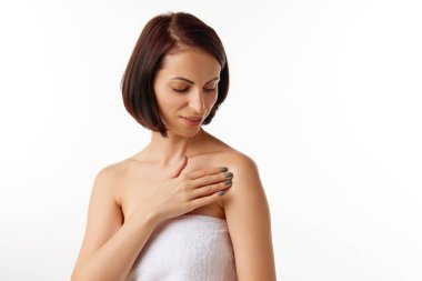 Çıplak omuzlarına beyaz arka plana cilt ürünleri uygulayan güzel bir kadın. Yaşlanma karşıtı prosedürler. Cilt bakımı. Güzellik, kaplıca, kozmetoloji, doğal ürünler kavramı