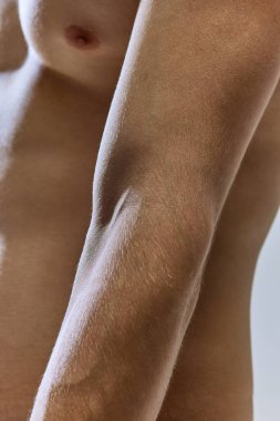 Kesilmiş portreyi kapat. Genç atletik erkek vücudu. Çıplak göğüs, mide, erkek kolu. Cilt bakımı kozmetik tedavi etkisi. Kavramsal gençlik, doğal güzellik, spor, sağlıklı yaşam tarzı. Boşluğu kopyala.