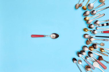 Çatal bıçak takımı. Üst manzara bir çay kaşığı dolusu çeşitli antika gümüş çatal bıçak ve altın kaşıklarla çevrili mavi stüdyo arka planı. Yemek kavramı, tatil, sofra kurma, retro, vintage