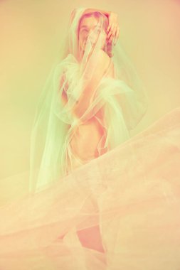 Sevgi, şefkat, duygusallık. Çıplak feminizm silueti kumaşa sarılıp eski yumuşak renkli fotoğraf efektine sarılıyor. Resim filtreleri. Kadın vücudunun doğal güzelliği, sanat konsepti. Önemli noktalar. Ad.