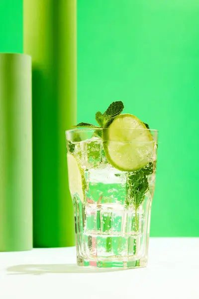Poster. Top view photo of lemonade with lime slices and mint against vivid contemporary colored studio background. Concept of summer refreshing, invigorating zest. Fresh twist, vibrant charm