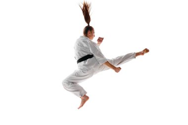 Dikiz aynası. Kadın profesyonel karate dövüşçüsü atlama, dövüş sanatları eğitimi beyaz arka planda izole edilmiş. Spor, eğlence, sanat, hobi, kültür kavramı. İlan, metin için boşluk kopyala.