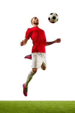 Genç bir adam, kırmızı spor giyimli profesyonel bir oyuncu ve yeşil çimenli beyaz arka planda futbol hileleri eğitiyor. Oyun, spor, eğlence, aktif yaşam tarzı kavramı.