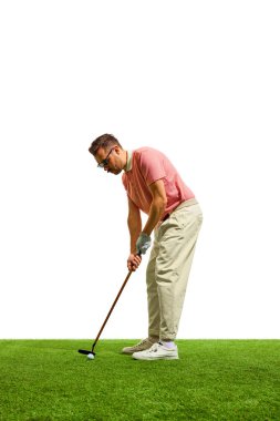 Yazın golf kulübünde yeşil çimlerin üzerinde profesyonel bir erkek golfçü. Golfçü deliğe ateş ediyor. Oyun, spor, eğlence anlayışı, sağlıklı ve aktif yaşam tarzı. İlan için alanı kopyala
