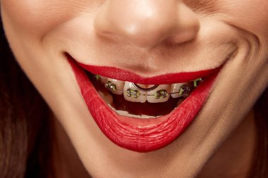 Ürkütücü gülümseme. Gülümseyen dudakları olan güzel bir genç kızın portresini yakından çek. Dudak boyası. Cilt bakımı rutini. Güzellik, diş, sağlık, diyet, spa tedavileri, kozmetik ürünleri, makyaj.