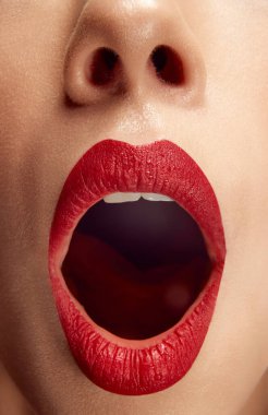 Esne. Kadının, ağzı açık, dolgun, parlak kırmızı dudaklı aşırı yakın plan fotoğrafı. Dudak boyası. Güzellik, makyaj, kozmetoloji, spa tedavileri, kozmetik ürünler. Ad
