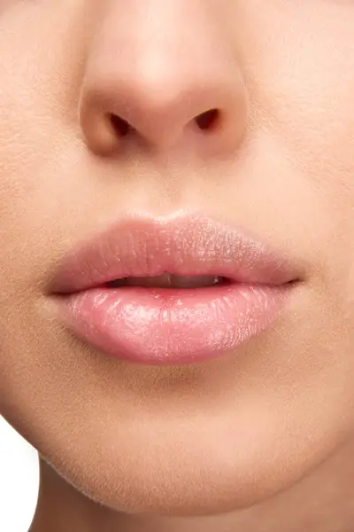 Perfect natural lip makeup. Close up photo of woman lips with glossy lipstick. Moisturizing chap stick for dry lips. Concept of beauty, make-up, cosmetology, spa treatments, cosmetic products. Ad