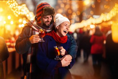 Noel 'den önce kış fuarında eğlenen, dışarıda mutluluktan kahkahalar atan mutlu bir çift. Birlikte vakit geçirin. Ulusal gelenek kavramı, kış tatili, moda, şenlik