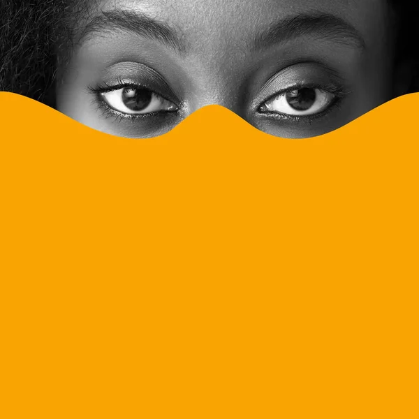 Poster. Contemporary art collage. Cropped monochrome portrait of young African-American female eyes selected by boldly orange paint. Concept of Black History Month, civil rights, culture. Ad
