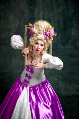 Klasik tarih karakteri gibi giyinmiş, modası geçmiş elbiseler giymiş ve klasik arka planda retro çerçeveden çıkmış bir kadın. Moda, tarz, tarih, yaratıcılık, çağların karşılaştırılması.
