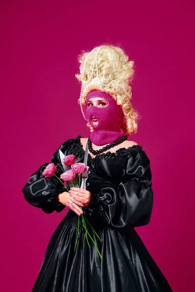 unrequited love. Portrait of queen, young lady dressed old fashioned dress in robber mask holding bunch of flowers with sharp knives. Concept of comparison of eras, love, romantic, style, fashion, ad.