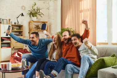 Mutlu ve gülen gençlerden oluşan bir grup belirleyici futbol maçını ve favori takımın zaferini izledi. Arkadaşlık kavramı, birliktelik, TV programı, online etkinlik, eğlence, şampiyonluk.