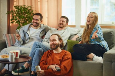 Gençlerin toplu portresi, arkadaşlar filmi dikkatle izler ve favori komedi filminin mutlu ve iyi sonla bitmesine sevinirler. Arkadaşlık kavramı, birliktelik, TV programı, online etkinlik, eğlence.