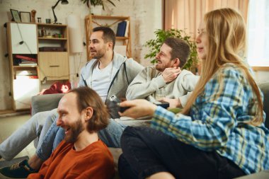 Oturma odasında oturan erkek ve kız çocuklarının grup portresi ve tüm zamanını beklenmedik bir şekilde yeni filmler izleyerek geçirmek. Arkadaşlık kavramı, birliktelik, TV programı, online etkinlik, eğlence.