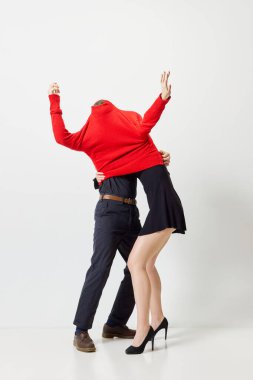 Kırmızı bir süveter içinde beyaz stüdyo geçmişine karşı duran genç ve sevimli bir çift. Duygularını gösterebilme yeteneği. Birleşin ve birleşin. Aşk kavramı, gençlik, modern ilişki, Sevgililer Günü, duygular