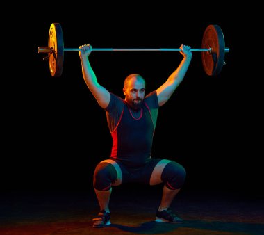 Güçlü, kaslı, genç sporcu, vücut geliştiren, halter kaldıran, siyah arka planda ağır yükler. Spor anlayışı, güç, spor, sağlıklı yaşam tarzı, güç, halter