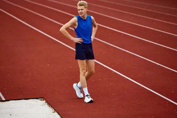 Uzun atlama eğitiminden sonra kum havuzunda dinlenen profesyonel sporcu genç adamın tam boy portresi. Spor, şampiyonluk, motivasyon, enerji kavramı.