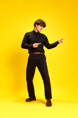 Neşeli, neşeli genç adamın tam boy portresi, iş hayatında başarının dansı ve kollarını canlı sarı stüdyo geçmişine doğru sallaması. İnsan duyguları kavramı, öğrenme. Ad