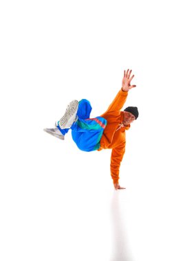 Genç, sportif bir adam, şık, parlak bir spor giysisi giyen, break dans elementleri, beyaz arka planda donuyor. Eylem kavramı, sanat, güzellik, spor, gençlik, yaratıcı meslek