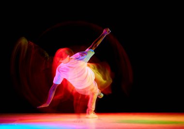 Dans gösterisi. Dans eden atletik adam, derin derin derin düşünme, break dans ve hip-hop ile siyah stüdyo arka planına karşı hareket bulanıklığı ile karışık neon ışığı altında. Gençlik kültürü kavramı, aktif yaşam tarzı, yaratıcılık, sanat.