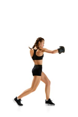 Kadın, profesyonel sporcu, boksör, temiz beyaz stüdyo arka planına karşı boks takımlarındaki hünerini sergiliyor. Bireysel spor kavramı, aktif yaşam tarzı, sağlık, zorluklar.