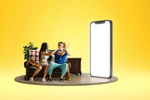 Family arguing. Man and woman sitting couch near on 3D model of mobile phone with empty screen over yellow background. Online payment, shopping, sale. Mockup for text, ad, design, logo