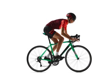 Spor giyim ve kask süren bisiklet süren genç bir adam, beyaz stüdyo arka planında izole edilmiş bir eğitim görüyor. Yan görüş. Spor, eylem, rekabet, güç ve dayanıklılık kavramı, sağlık
