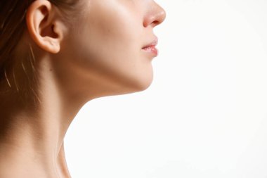 Kırpılmış kadın yüzü, beyaz stüdyo arka planında izole edilmiş boyun. Çift çene küçültme. Kavramsal gençlik, doğal güzellik, sağlıklı yaşam tarzı. Reklam için negatif boşluk
