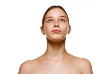 Çıplak omuzlu, lekesiz ciltli, izole edilmiş beyaz stüdyo geçmişine bakan güzel esmer kadın portresi. Cilt bakımı kozmetik tedavisi. Gençlik kavramı, doğal güzellik. Ad